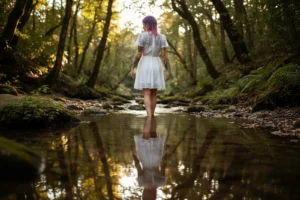 Modella di spalle in abito bianco corto cammina nel ruscello, riflesso nell'acqua ferma