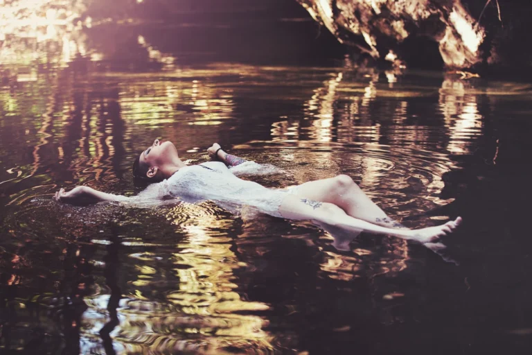 Fotografo fashion Imperia - modella fluttuante in acqua dorata