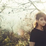 Dittico panoramico, ragazza in abito nero tra alberi nella foschia autunnale, fotografia moda evocativa