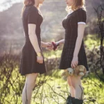 Due modelle si fronteggiano, una offre un fiore e l'altra tiene un orsacchiotto, fotografia fashion all'aperto