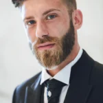 Ritratto ravvicinato dello sposo con barba curata e occhi azzurri, abito scuro | Fabio Zenoardo