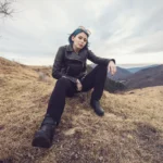 Fotografo artistico Imperia - Yuriko giacca pelle seduta prato montagne