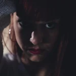 Fotografo dark Imperia - sguardo intenso sotto frangia rossa