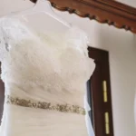 Dettaglio della fascia di perle e cristalli sulla vita dell'abito da sposa bianco | Fabio Zenoardo