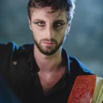 Ritratto attore Ghost Tour con makeup gotico, libro con simbolo pentacolo, luce teatrale