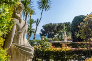 Giardino formale con statua in pietra, fontana e vegetazione mediterranea con vista sul mare, Liguria