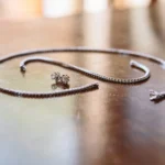 Collana tennis di diamanti e orecchini punto luce su superficie in legno | Fabio Zenoardo fotografo