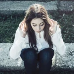 Fotografo ritratto Imperia - Yuriko seduta gradini mani capelli sguardo basso pensierosa