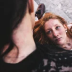 Fotografo dark Imperia - modella rossa sdraiata guarda l'altra