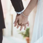 Mani degli sposi intrecciate con fede nuziale e bracciale di diamanti | Fabio Zenoardo