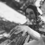 Mano della sposa con fede nuziale appoggiata su recinzione in legno, bianco e nero | Fabio Zenoardo