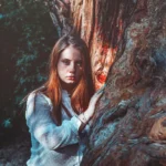 Fotografo moda Liguria - modella albero camicetta bianca luce natura