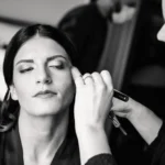 Make-up artist applica ombretto con pennello alla sposa in bianco e nero | Fabio Zenoardo