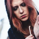 Fotografo artistico Liguria - modella cappuccio fiammifero vento scuro