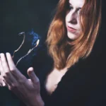 Fotografo dark Imperia - modella rametto fiamme fumo blu capelli rossi