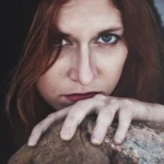Fotografo dark Imperia - ritratto sguardo intenso roccia capelli rossi