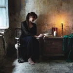 Fotografo dark Liguria - modella legge libro luce candela interno fatiscente
