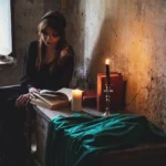 Fotografo artistico Imperia - modella seduta libro candele interno gotico