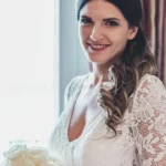 Ritratto di sposa sorridente con bouquet di rose bianche e abito in pizzo | Fabio Zenoardo