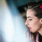 Ritratto di profilo della sposa con rose rosse nei capelli e labbra rosse | Fabio Zenoardo