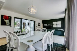 Sala da pranzo con tavolo bianco laccato, sedie barocche, lampada a sfera e opere d arte contemporanea sulle pareti