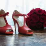 Scarpe a tacco aperto rosse e bouquet di rose rosse su parquet in legno | Fabio Zenoardo