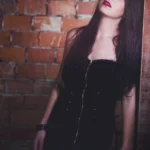 Fotografo dark Imperia - modella abito nero zip dorata muro mattoni