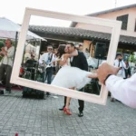 Sposo solleva la sposa con band dal vivo sullo sfondo e cornice photo booth | Fabio Zenoardo