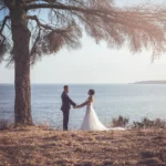 Sposi mano nella mano sul mare ligure con un pino marittimo | Fabio Zenoardo fotografo matrimoni