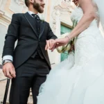 Sposi si tengono per mano sulle scale di una chiesa barocca con facciata ornata | Fabio Zenoardo