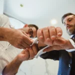 Sposo e amici fissano i gemelli alla camicia, ripresa dal basso verso l'alto | Fabio Zenoardo