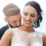 Sposo sussurra all'orecchio della sposa che ride, sfondo marino ligure | Fabio Zenoardo