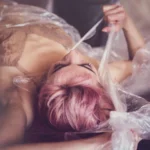 Fotografo artistico Imperia - modella capelli rosa distesa plastica trasparente