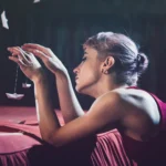 Fotografo artistico Liguria - modella distesa barchetta carta mani luce laterale