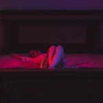 Fotografo dark Liguria - modella letto antico candele luce rossa scena teatrale