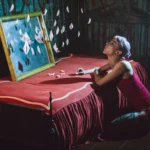 Fotografo artistico Imperia - modella rosso inginocchiata dipinto barchette carta appese