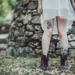 Fotografo artistico Imperia - dettaglio gambe tatuaggi stivali bordeaux abito bianco