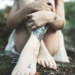 Fotografo artistico Liguria - dettaglio piedi tatuaggi colorati rocce muschio