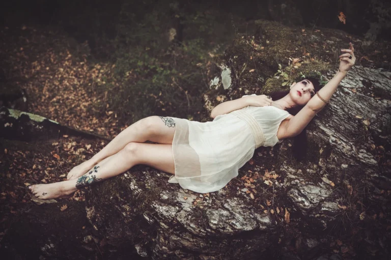 Fotografo fashion Imperia - modella abito bianco distesa rocce bosco