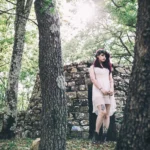 Fotografo fashion Liguria - modella alberi muro pietra bosco abito rosa