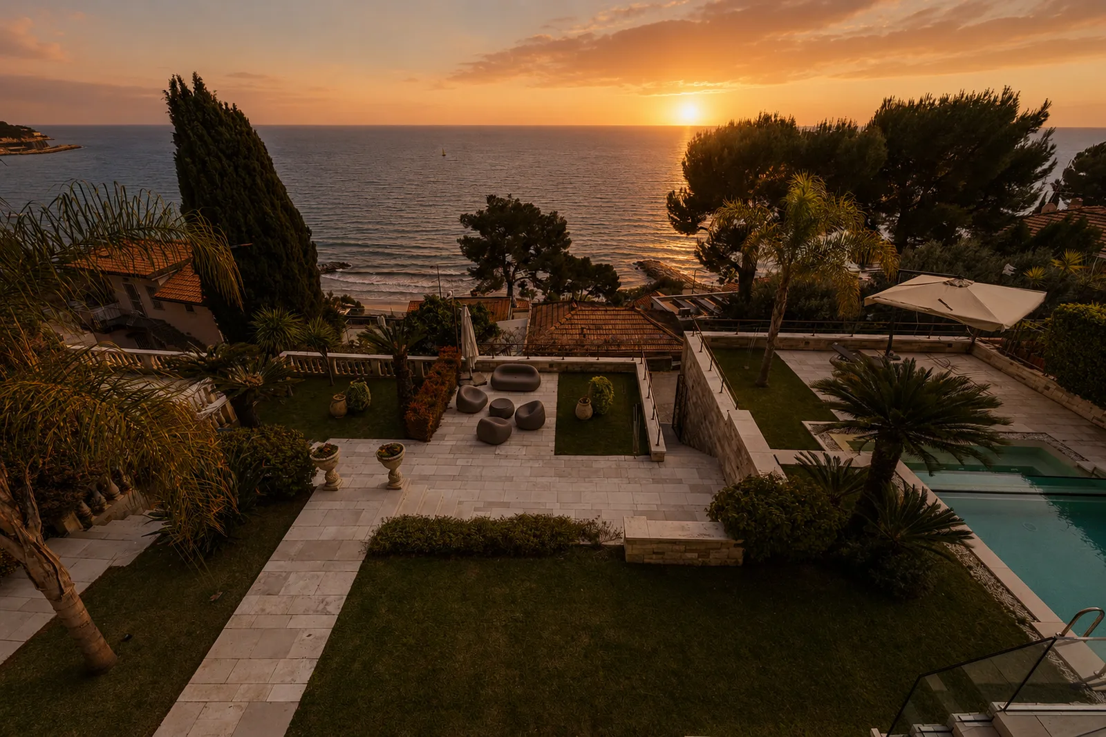 Vista aerea al tramonto di villa di lusso con piscina e giardino fronte mare a Imperia, Liguria