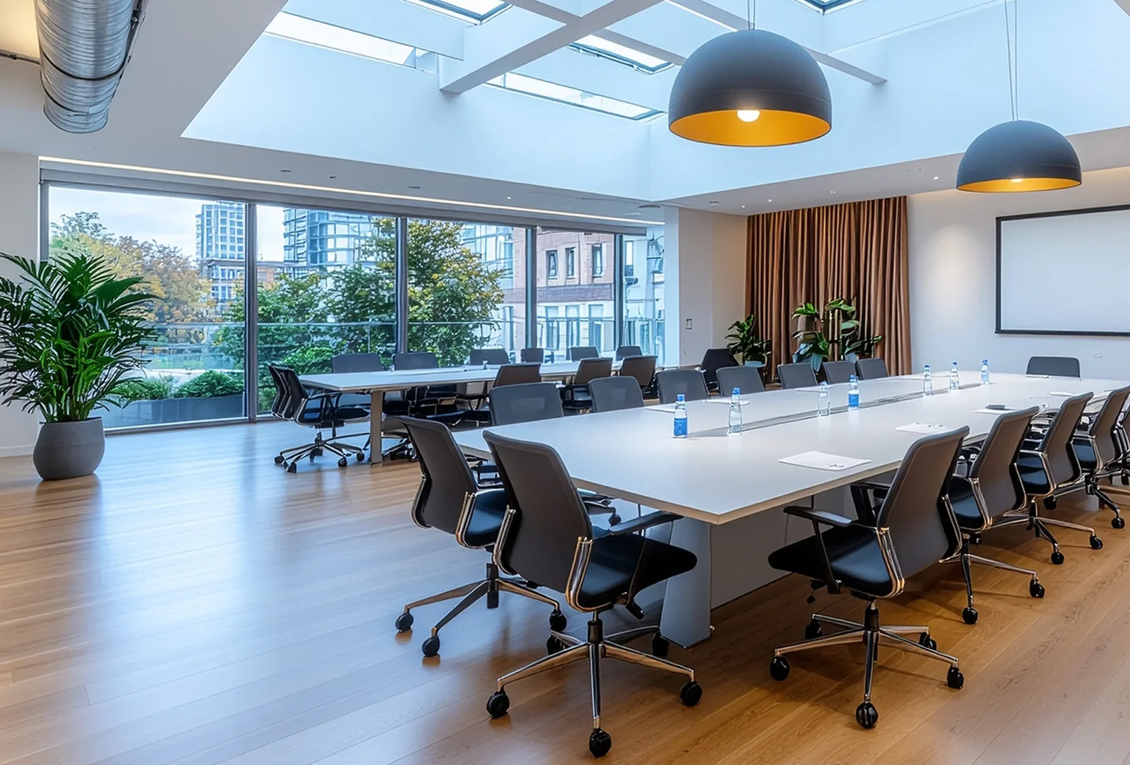 Sala riunioni con grande tavolo, sedie ergonomiche e finestre panoramiche su giardino, senza persone