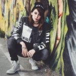 Fotografo street Imperia - modella accovacciata giacca scritte giapponesi murale graffiti