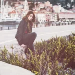 Fotografo artistico Liguria - modella seduta muretto vista porto Imperia barche
