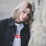 Fotografo ritratto Imperia - ritratto modella bionda giacca nera muro sassi choker