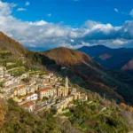 Veduta aerea del borgo di Cenova, frazione di Rezzo, tra i boschi autunnali del Parco delle Alpi Liguri